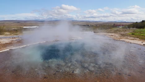 Steaming-blue-hot-spring-in-Haukadalur-Valley-in-South-Iceland,-Wide-low-shot