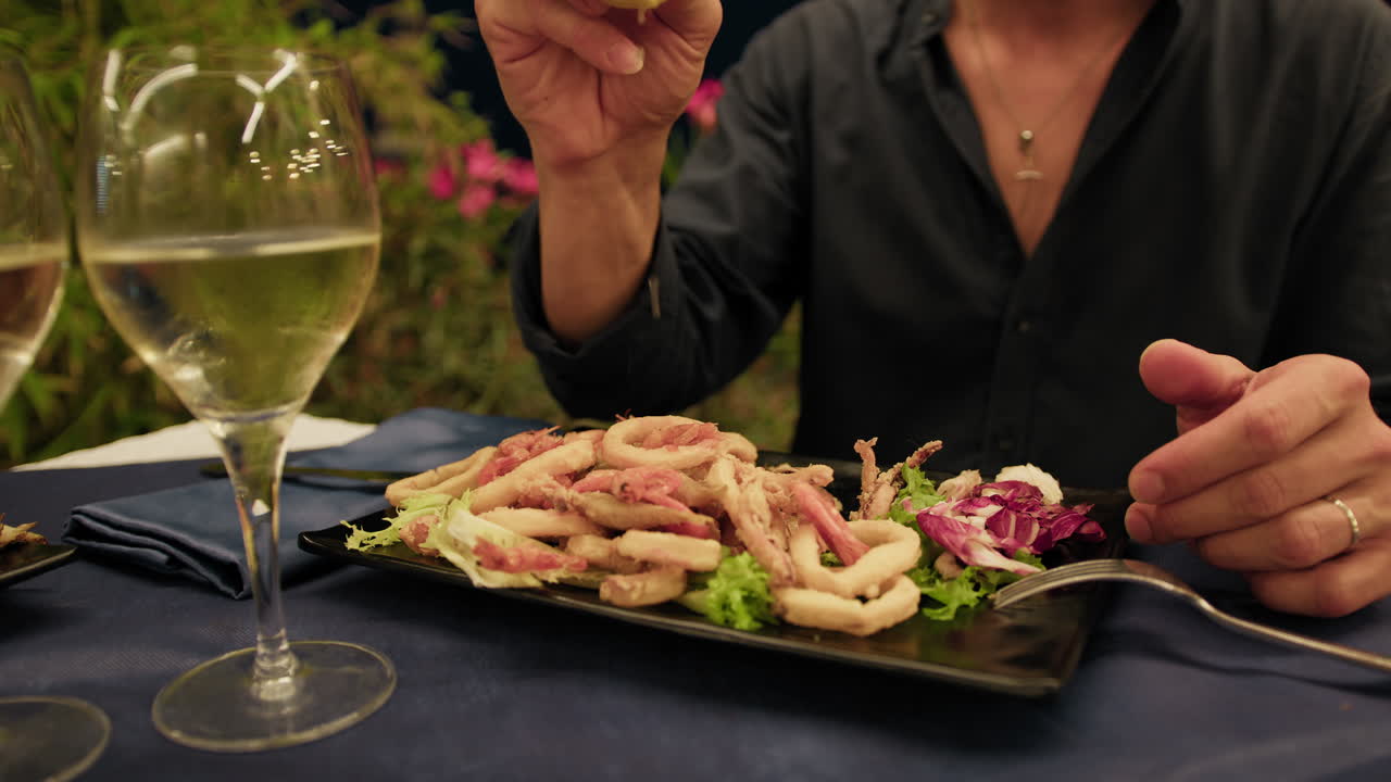 Man Squeezing The Lemon On Top Of The Fried Fish At The Beach Resort