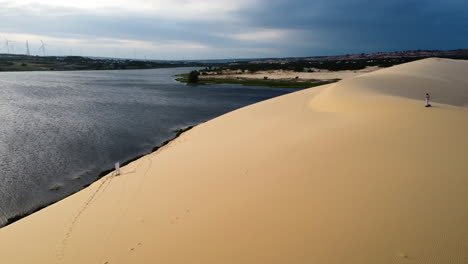 Aerial-circling-over-white-sand-dunes-of-Vietnam,-unrecognizable-lone-man