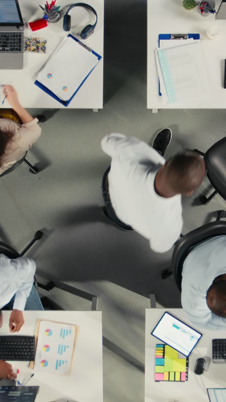 Vertical Video Top down view zoom out of business people review diagrams