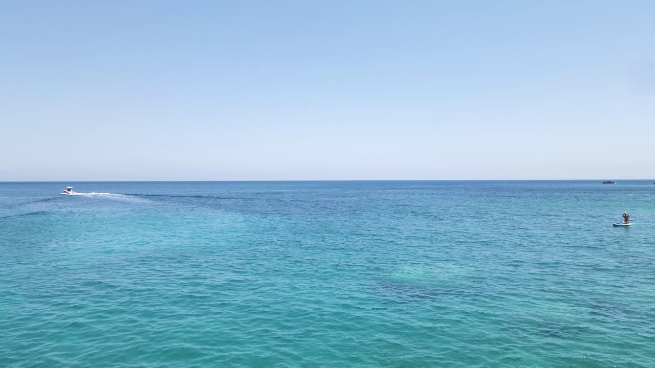 드론이 그리스 자킨토스 섬의 청록색 바다 표면을 스쳐 지나간다.