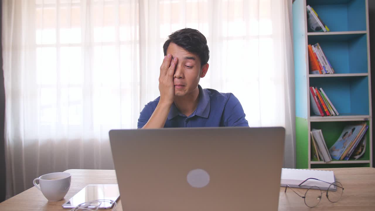 Tired worker at his laptop