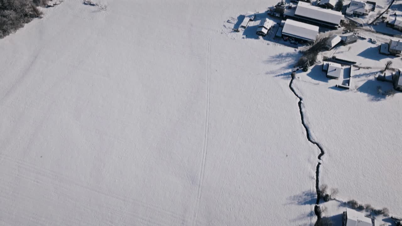 Snowy landscape with houses and a shadow in the giffre valley , aerial view