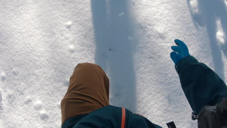 un hombre caminando por una montaña soleada de invierno