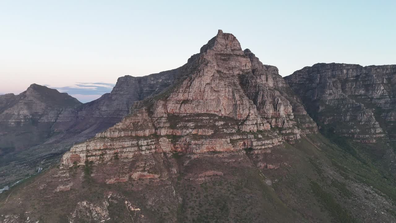 Aerial view of Table Mountain in Cape Town, South Africa at sunset, showcasing dramatic cliffs, cityscape, and vibrant sky over the Atlantic Ocean