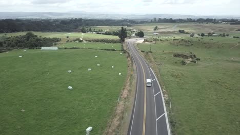 aerial view of road through green field