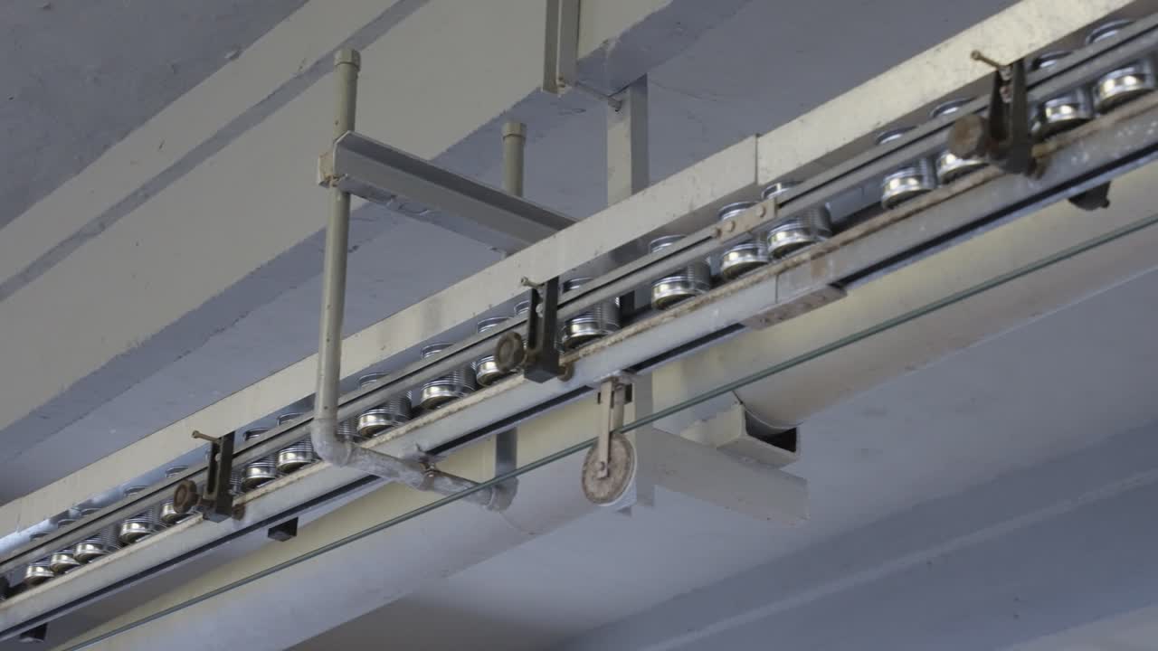 latas que se mueven en una cinta transportadora en una línea de producción de alimentos, con automatización, envasado, sellado y control de calidad en un entorno industrial