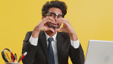 Indian-business-man-makes-symbol-of-love,-showing-heart-sign-to-camera,-express-romantic-feelings