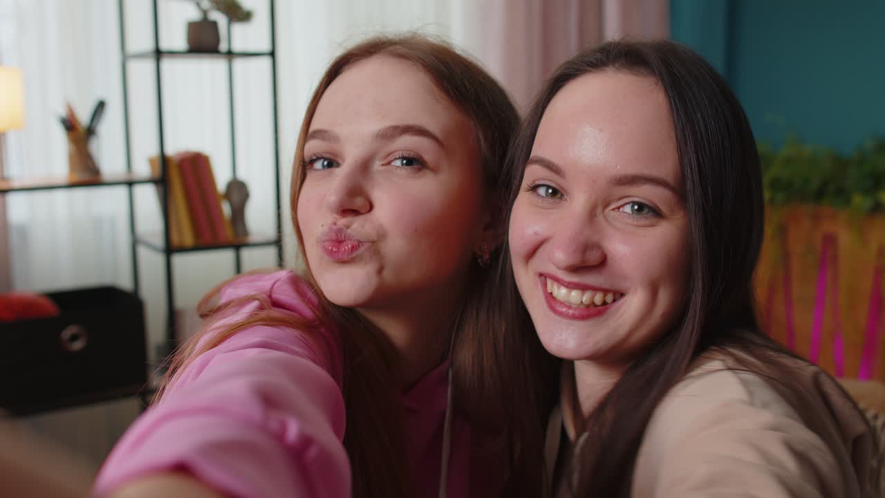 Dwie kobiety, przyjaciółki, rodzeństwo, blogerki w domu śmieją się, spędzają wolny czas, robiąc zdjęcia selfie