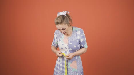 unhappy person measuring her weight with a tape measure.