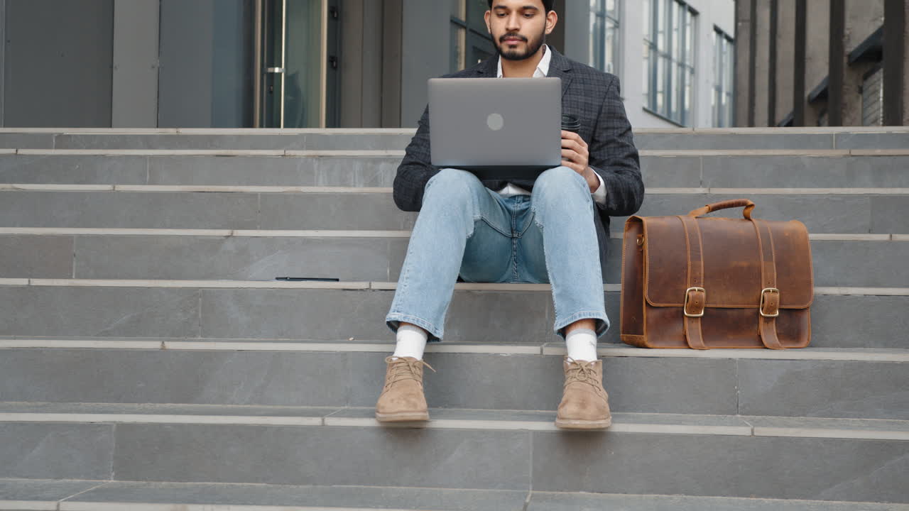 Businessman Working on Laptop Outdoors on Stairs