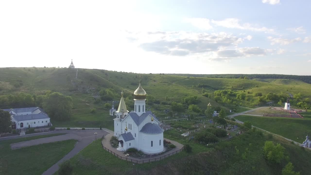 белый храм с куполами в горах летом