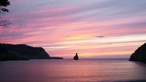 wunderschöner rosafarbener sonnenaufgangshimmel über dem strand, benirras, ibiza, spanien, weitwinkelaufnahme nach oben geneigt