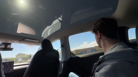 Person looking out the back window of a car