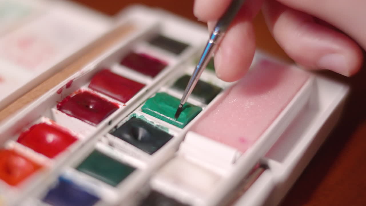 수채화 팔레트 그린에서 페인트 브러시를 가진 사람