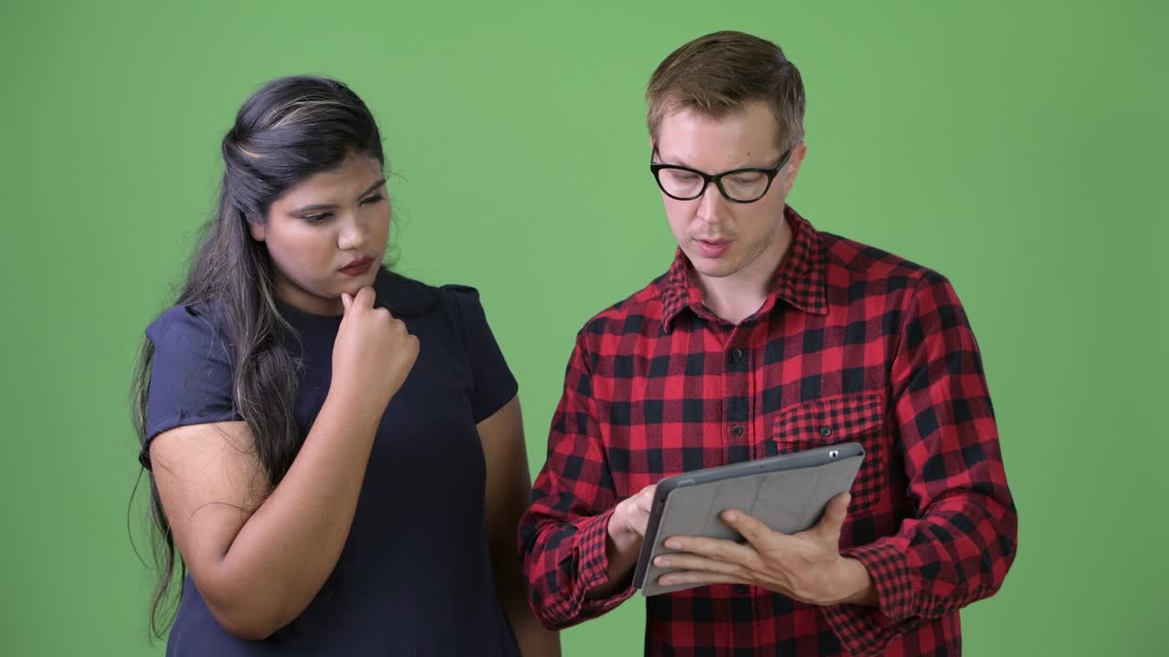 joven pareja de negocios multiétnica juntos contra un fondo verde