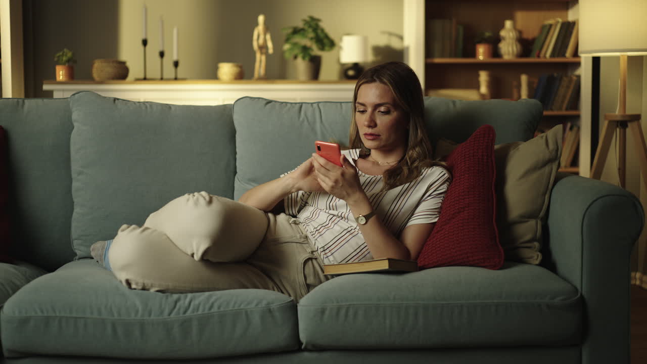 스마트폰으로 소파에서 휴식을 취하는 여자