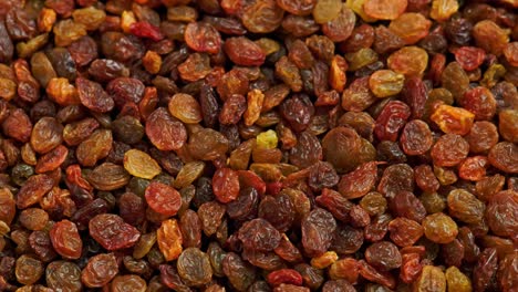 looped spinning full frame background of yellow and brown raisins pile