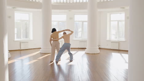bailarines masculinos contemporáneos entrenando movimientos de baile en medio del estudio