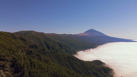 pico del teide en el fondo con su hermosa manta de nubes donde se pueden ver las dimensiones del volcán
