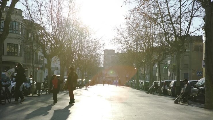 Sonnige Stadtstraße mit Fußgängern