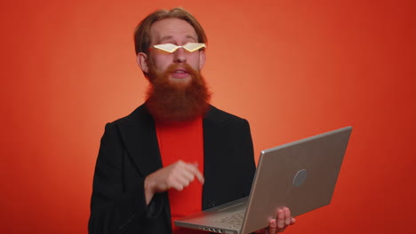 hombre feliz trabajando en línea en una computadora portátil mostrando el pulgar hacia arriba comentarios positivos, como, ganar la lotería, buena oferta
