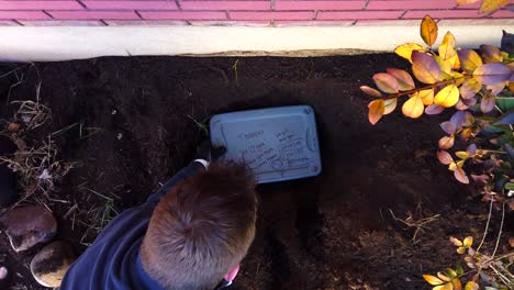 Digging-and-measuring-a-dead-house-pet’s-grave-and-hole-in-a-flower-garden