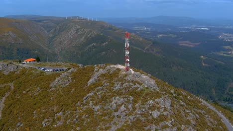 aerial circle dolly view of telecommunications mast on rocky hillside viewpoint in miradoiro da curota