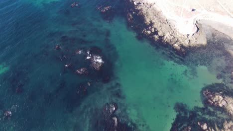 Die-Nach-Oben-Geneigte-Luftaufnahme-Gibt-Den-Blick-Auf-Das-Tiefblaue-Meer-Und-Die-Wüstenküste-Frei