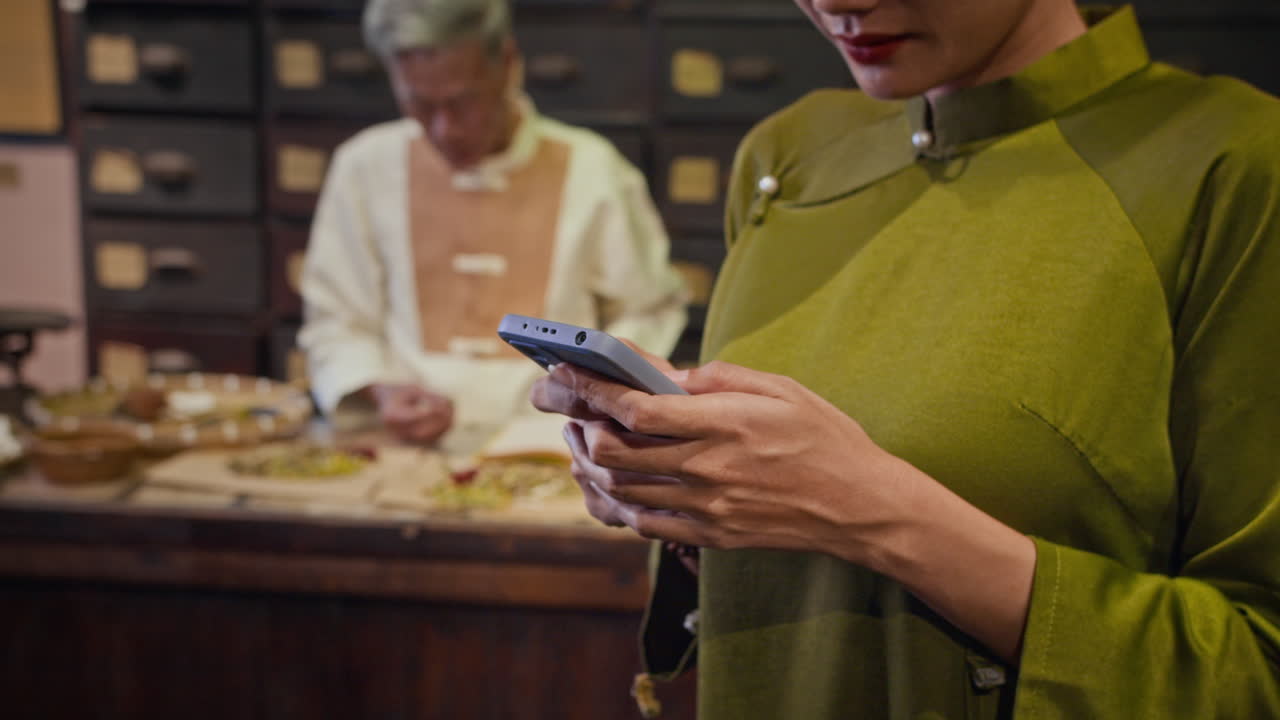 Woman with Phone Posting for Website of Chinese Medicine