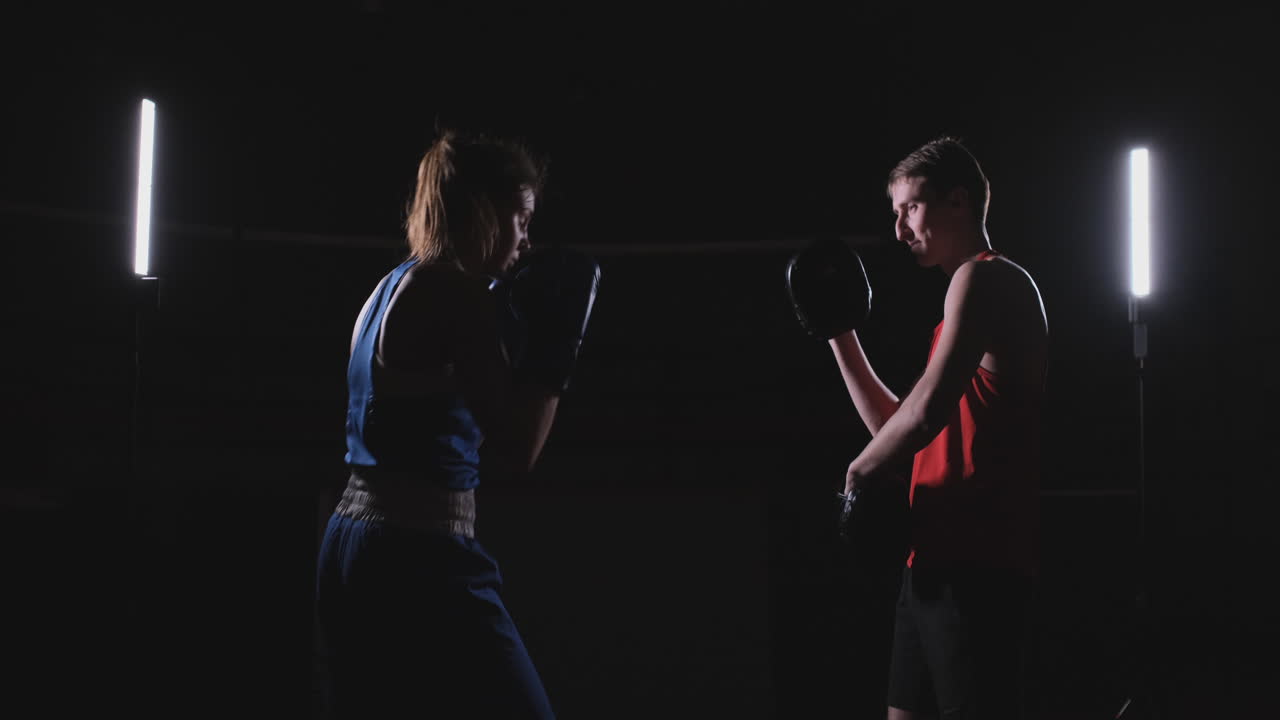 mujer deportista de acondicionamiento físico boxeo golpes enfoque guantes disfrutando de ejercicio intenso mujer luchadora entrenando amiga en el gimnasio entrenando juntos en cámara lenta