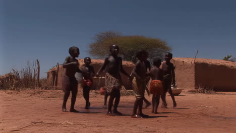 children playing with water in a rural african village