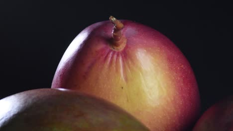 ripe mangoes gyrating in black background