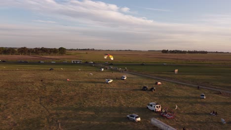 A-paramotor-landing-on-a-green-meadow-at-sunset