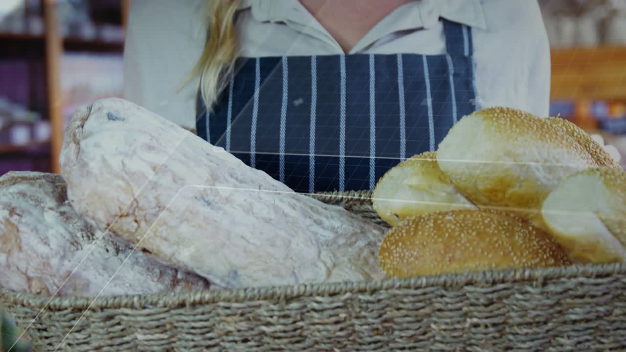 Baker holding bread basket as camera rising revealing smile, overlays crossing frame showing goods