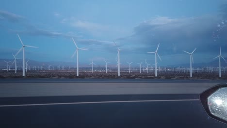 Pasando-Por-Un-Aerogenerador-Al-Lado-De-La-Carretera-Durante-La-Hora-Azul