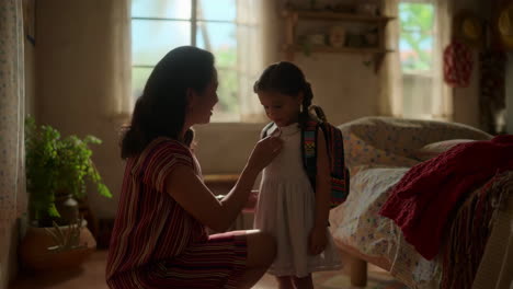 mother helping daughter prepare for school