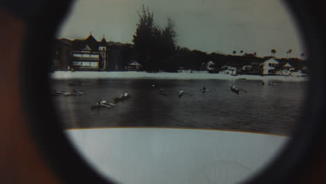 vintage black and white photograph of outrigger boats on waikiki beach, magnified with antique lens