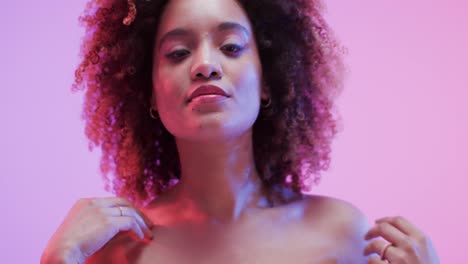 biracial woman with dark curly hair in blue and pink light, slow motion