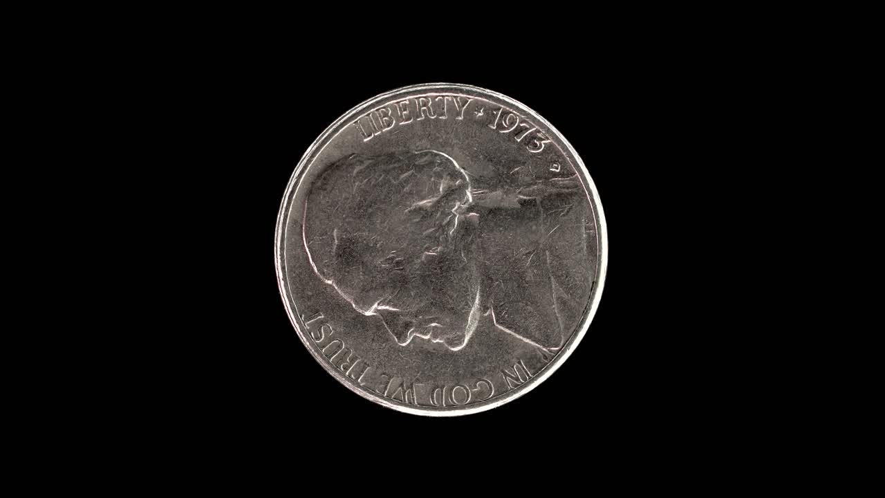 United States 1973 5 cent coin obverse with Thomas Jefferson first portrait rotating on black background