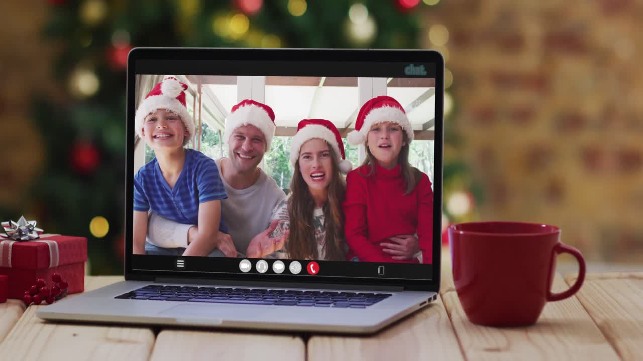 familia feliz usando sombreros de santa en una llamada de video portátil, con decoraciones de navidad y árbol