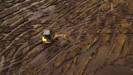 excavator drives in muddy field to work on solar power plant