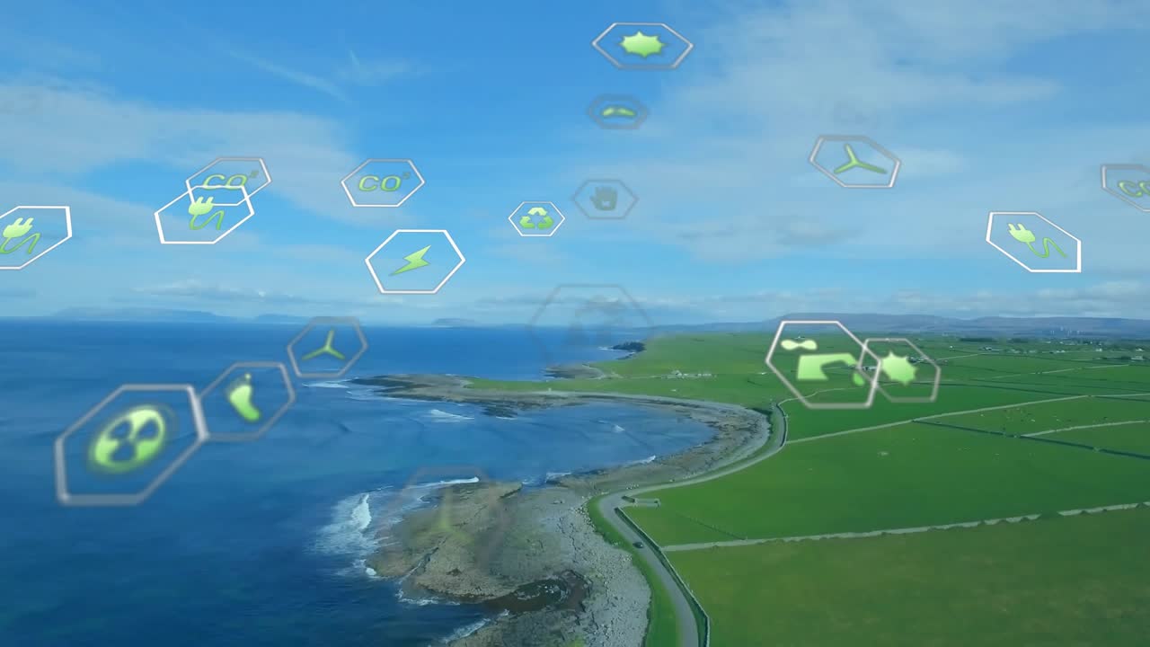 When aerial camera hovering coastline, icons emerging, drifting, dissolving showing energy data