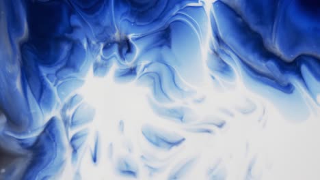 Video-of-close-up-of-blue-and-white-ink-in-water-with-copy-space