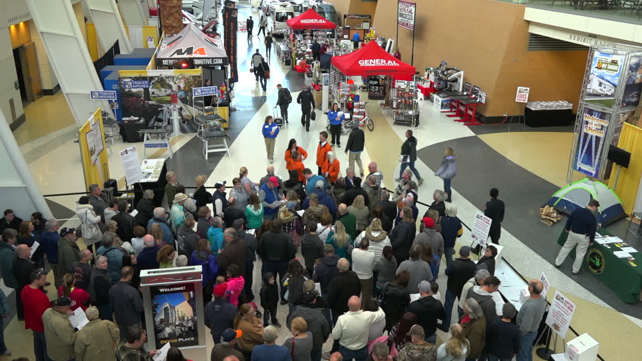 la gente se agolpa en un centro de convenciones para asistir a una feria comercial