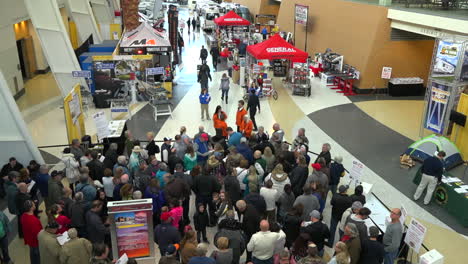 people crowd into a convention center to attend a trade show