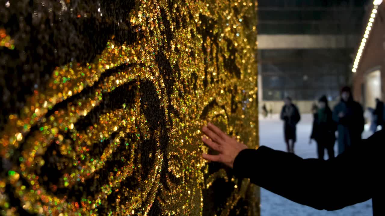 Mano che tocca decorazione murale con glitter dorati di notte
