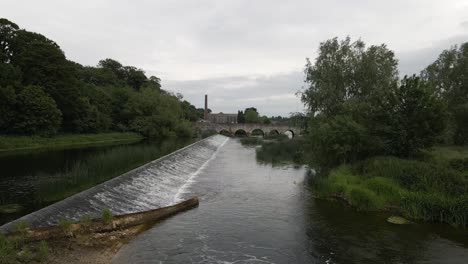 toma de un dron de un río con un viejo puente cruzándolo en irlanda
