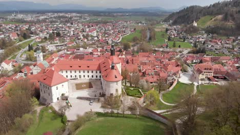 a historic medieval castle in slovenia, a popular tourist attraction and old town in the background