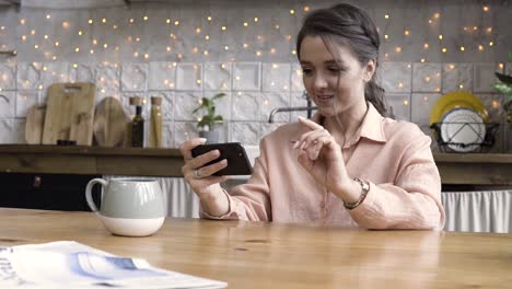 woman using phone in kitchen